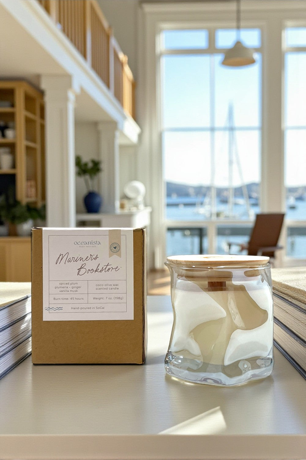 Candle and packaging on a surface with a bright room in the background